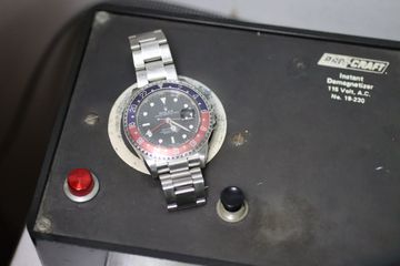 Rolex GMT watch positioned on a demagnetization device