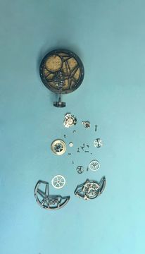 Disassembled tourbillon movement components organized on a workshop mat