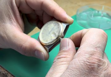 Fogged vintage watch held during crown inspection