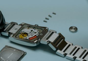 Open Cartier quartz watch with its movement and battery compartment exposed