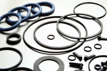 Assorted black rubber sealing rings arranged on a white background