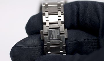 Audemars Piguet bracelet and clasp held in a black glove for inspection