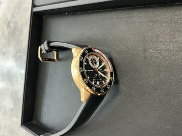Gold chronograph resting in a padded intake tray