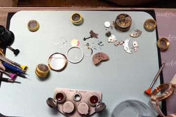 Disassembled diamond-set watch organized for component inspection