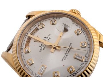 Brown corrosion spots across the dial of a gold luxury watch