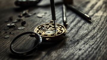 Vintage mechanical watch movement surrounded by watchmaking tools