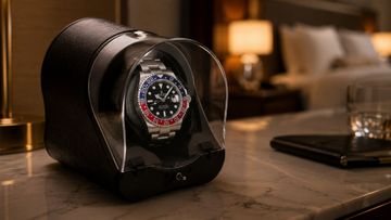 Illustrative hotel-room scene with a luxury watch displayed in a single watch winder