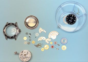 Rolex Submariner 1680 fully disassembled showing case, dial and movement parts